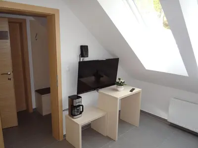 a living room with a tv and a table at Relax Center Olimian in Podčetrtek