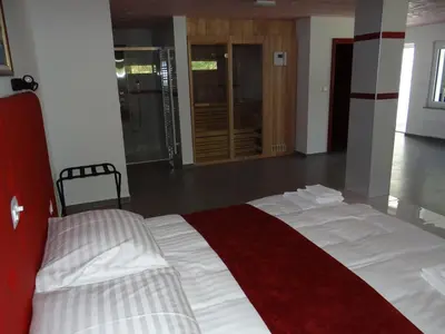 a bedroom with a bed with a red and white blanket at Relax Center Olimian in Podčetrtek