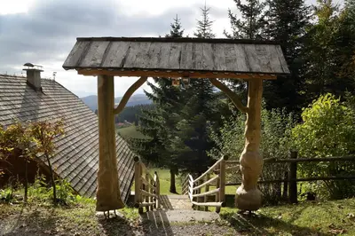 a wooden gazebo with a gate and a fence at Charming Chalet Rogla in Hudinja