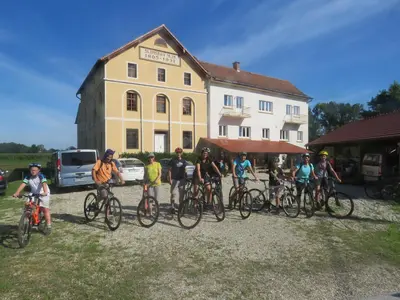 a group of people on bikes in front of a building at Mill House Apartment and Camping in Ljutomer