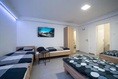 a bedroom with two beds and a tv on the wall at Apartments Teja in Kranjska Gora