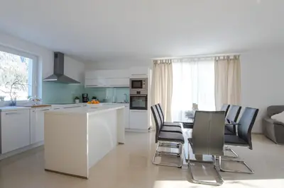 a kitchen and living room with a table and chairs at Apartments Teja in Kranjska Gora