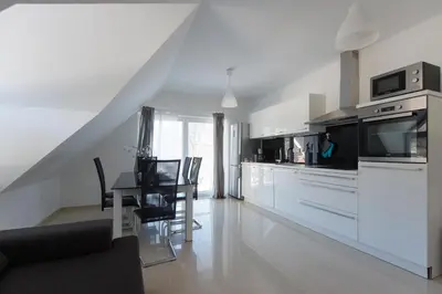 a kitchen with white cabinets and a table with chairs at Apartments Teja in Kranjska Gora