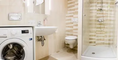 a bathroom with a washing machine and a sink at WH Apartments in Ljubljana