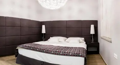 a bedroom with a large bed with a large headboard at WH Apartments in Ljubljana