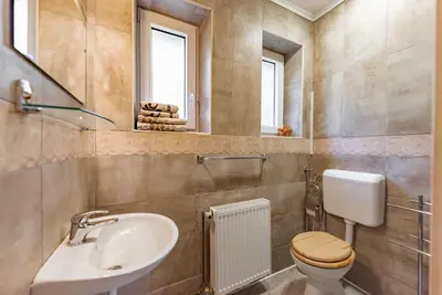 a bathroom with a sink and a toilet and a mirror at APARTMENTS ROGLA JURGOVO - Ski in Ski out in Lukanja