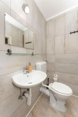 a white bathroom with a toilet and a sink at APARTMENTS ROGLA JURGOVO - Ski in Ski out in Lukanja