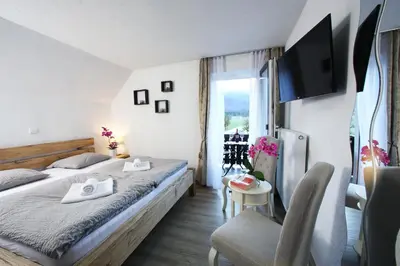 a hotel room with a bed and a tv at Hiša Pr'Pristavc in Bohinj