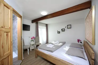 a bedroom with a bed and a table with a chair at Hiša Pr'Pristavc in Bohinj