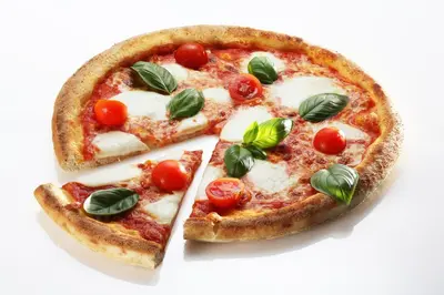 two slices of pizza with tomatoes and basil on it at Hiša Pr'Pristavc in Bohinj