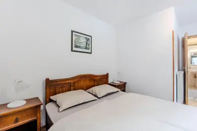 a bedroom with a bed and a table and a lamp at Apartments Mija in Krotica