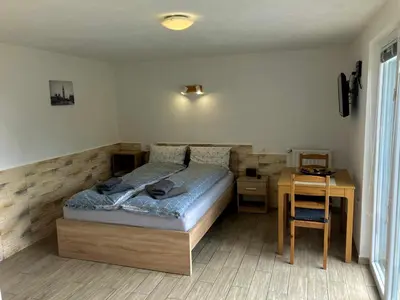 a bedroom with a bed and a table and a desk at Apartment Ozebek in Cerkno