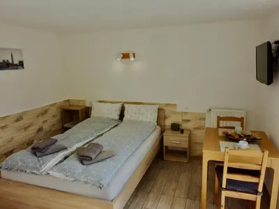 a bedroom with a bed and a table and a desk at Apartment Ozebek in Cerkno