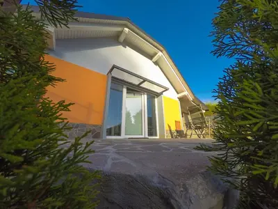 a house with a large window on the side of it at Apartment Ozebek in Cerkno