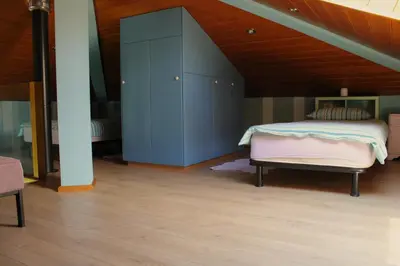 a bedroom with a bed and a blue cabinet at Apartment Dandelion in Branik
