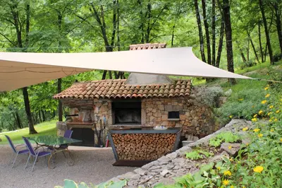 an outdoor grill with a white umbrella over it at Apartment Dandelion in Branik