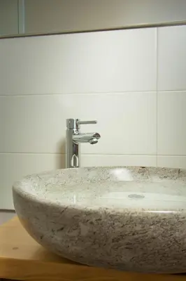 a marble sink in a bathroom with a mirror at Apartment Dandelion in Branik