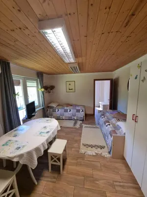 a room with two beds and a table in it at Dobra Hiša Zdravja Čičarija in Golac