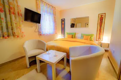 a bedroom with a bed and a couch and a table at Dobra Hiša Zdravja Čičarija in Golac