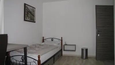 a small bedroom with a bed and a table at Dom Vita Sticna in Ivančna Gorica