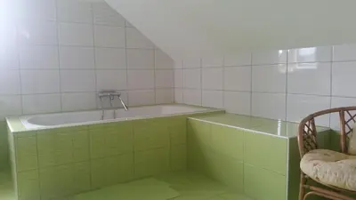 a bathroom with green and white tiled walls and a sink at Dom Vita Sticna in Ivančna Gorica