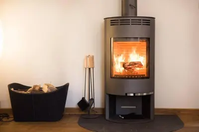 a fireplace with a fire in a living room at Stylish Penthouse with large terrace in Most na Soči