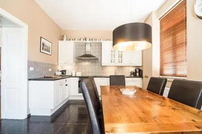 a kitchen with a wooden table and black chairs at Stylish Penthouse with large terrace in Most na Soči