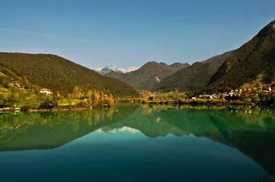 a large body of water with mountains in the background at Stylish Penthouse with large terrace in Most na Soči