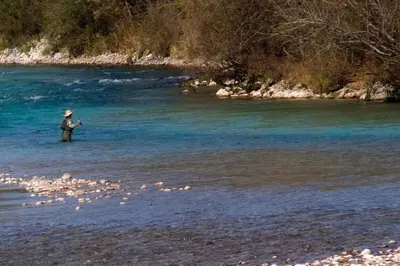 a man standing in the water in a river at Stylish Penthouse with large terrace in Most na Soči
