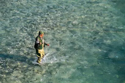 a man standing in the water holding a kite at Stylish Penthouse with large terrace in Most na Soči