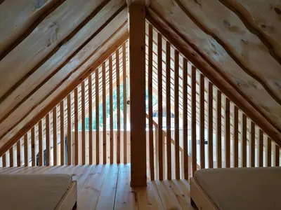 a wooden attic room with a roof with wooden beams at Guesthouse Planinski Dom Majerhold in Solčava