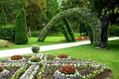 a garden with an arch and flowers in the grass at Farm Stay Žagar in Mozirje