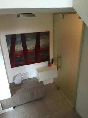 a bathroom with a painting on the wall at Angel's Nest Apartment in Komenda