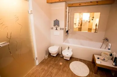 a bathroom with a tub and a toilet and a sink at Angel's Nest Apartment in Komenda