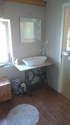 a bathroom with a white sink and a mirror at Angel's Nest Apartment in Komenda