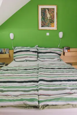 a bed in a bedroom with a green wall at Apartments Sasha in Bled