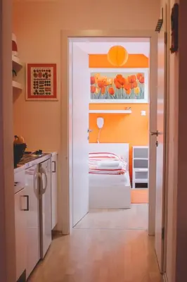 a kitchen with a door open to a room with a bed at Apartments Sasha in Bled