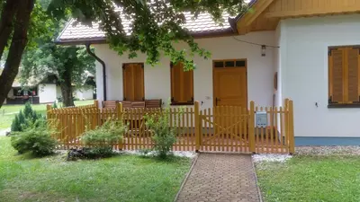 a house with a wooden fence in the yard at Apartment Borovnica in Moravske Toplice