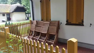 a group of wooden chairs sitting on a porch at Apartment Borovnica in Moravske Toplice