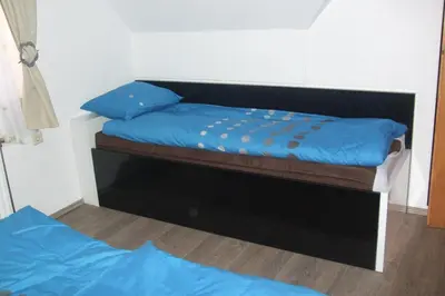 a bedroom with two beds with blue sheets at Apartment Borovnica in Moravske Toplice