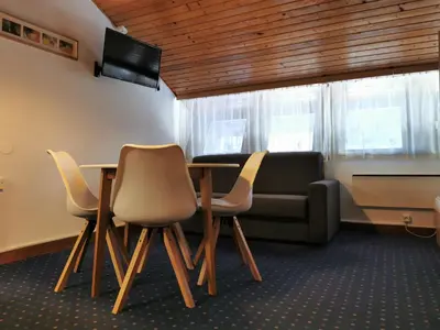 a room with a table and chairs and a couch at Apartma Svizec Rogla in Zreče