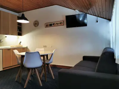 a living room with a table and a couch at Apartma Svizec Rogla in Zreče