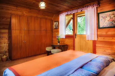 a bedroom with a bed in a wooden room at Chalet Romantic in Zgornje Jezersko