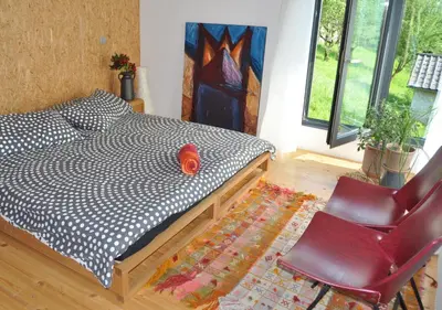 a bedroom with a bed and a red chair at Holiday Home Hisa Gusta in Most na Soči