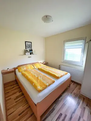 a bedroom with a bed with yellow sheets and a window at Apartments Sole in Podčetrtek