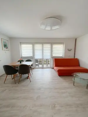 a living room with a red couch and a table at Apartments Sole in Podčetrtek