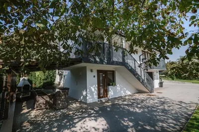 a white house with a tree in front of it at Apartments Sole in Podčetrtek
