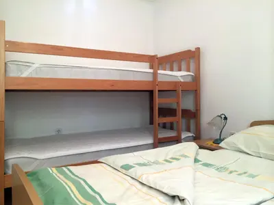two bunk beds in a room with a bed at Apartment CDR in Zreče