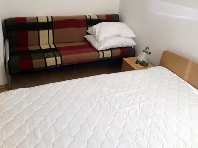 a bed and a couch in a room at Apartment CDR in Zreče