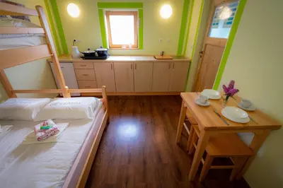 a small room with a bunk bed and a table at Počitniška hiška Pod Skalco in Kamnik